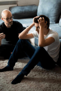 therapist and patient sit on the floor as the patient is having a mental health crisis